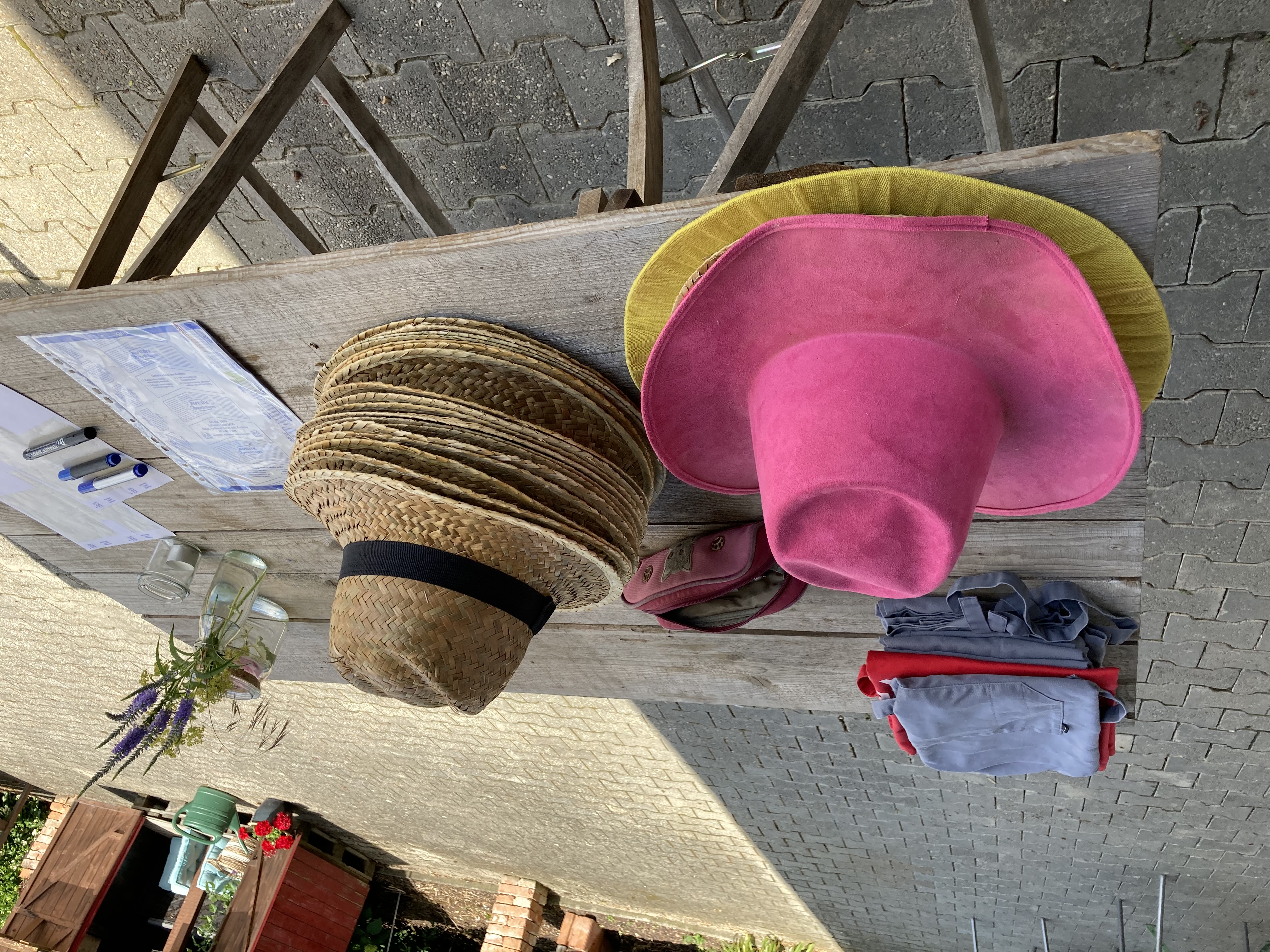 verschiedene Hüte liegen bereit am Tisch - die Gruppe kann die Strohüte aufsetzten - das Team der Artzpraxis  startet mit der Bauernhofrallye 