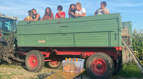 Touristen genießen eine Fahrt am Anhänger bei Straubing an der kleinen Laaber bei Atting-trinken ein Glas Kuerbissecco-haben-Spass